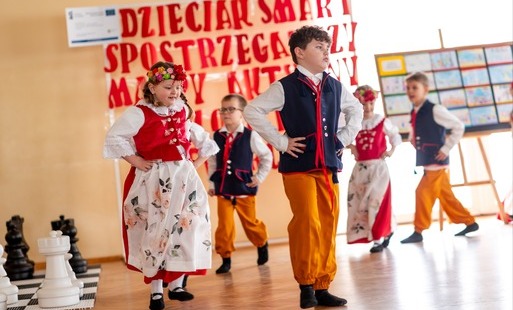 zdjęcie z imprezy przedstawia dzieci w strojach ludowych